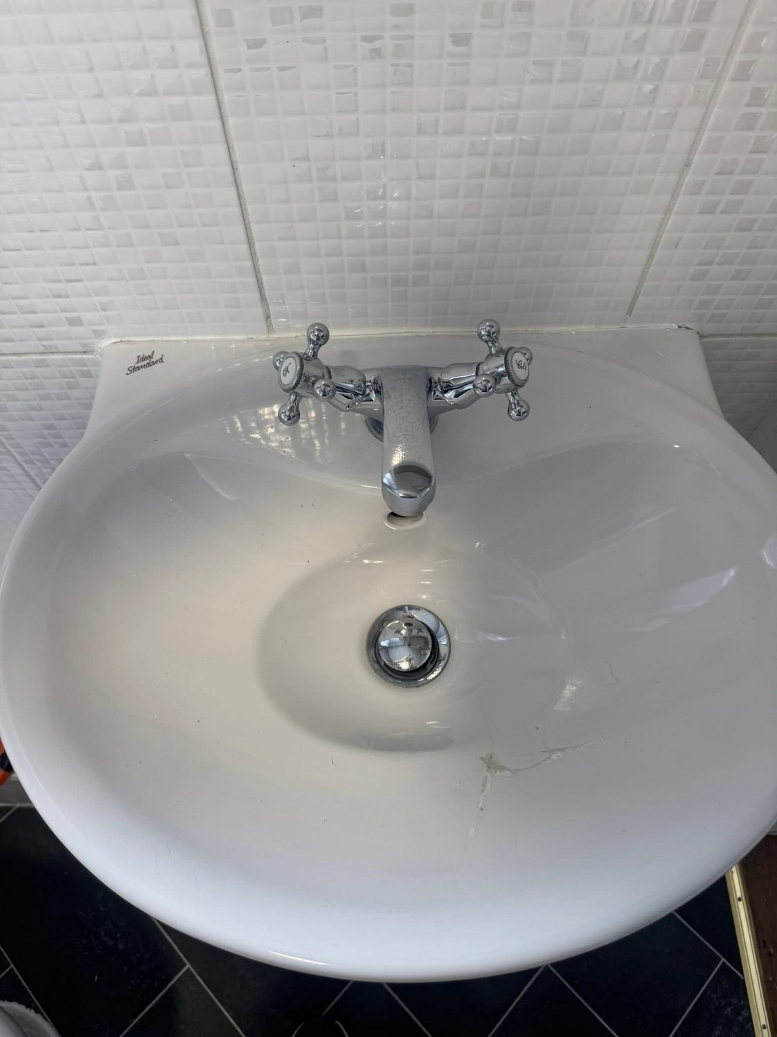 Old cracked basin with corroded waste