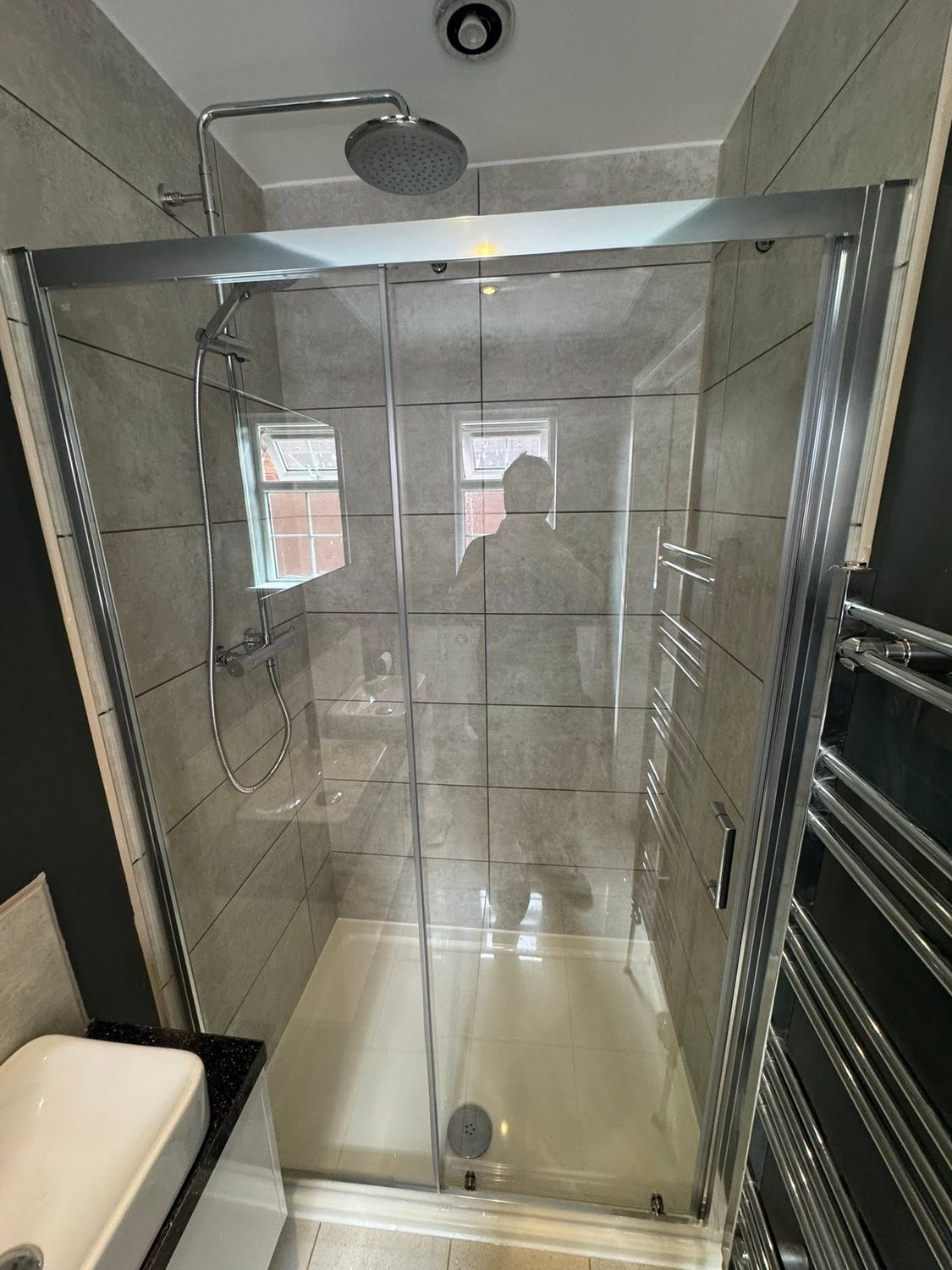 A walk-in shower re-tiled and refitted by L.C Plumbing Services